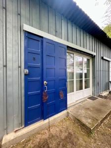 a blue door on the side of a building at La cabanne aux bambous in Villenave-dʼOrnon