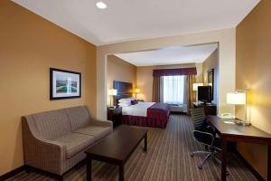 a hotel room with a bed and a couch at Hotel Willowbrook in Houston