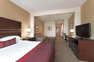 a hotel room with a bed and a flat screen tv at Hotel Willowbrook in Houston