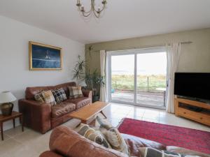 a living room with a couch and a tv and a table at Sealladh in Appin