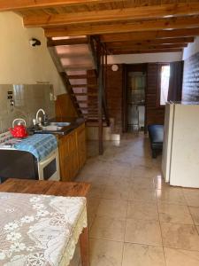 a kitchen with a refrigerator and a table in a room at Torres del Piltri in El Bolsón