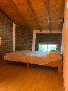 a bed in a room with a brick wall at Torres del Piltri in El Bolsón