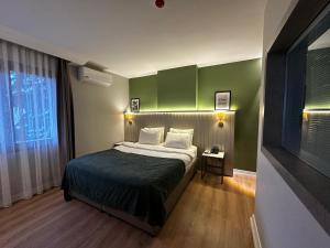 a bedroom with a bed with a green wall at OTTO X Hotel in Kavaklıdere