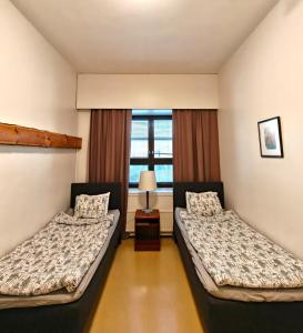 two beds in a room with a window at Majoitus Fox in Kuopio