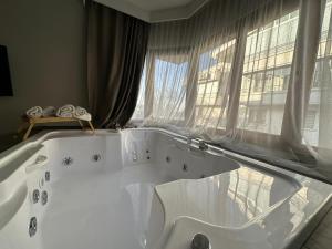 a large white bath tub in a room with windows at OTTO X Hotel in Kavaklıdere +198 photos