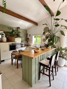 a kitchen with a large island with a wooden counter top at Villa avec piscine Proche de ROYAN in Sémussac