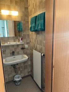 a small bathroom with a sink and a mirror at Hotel Bellevue in Sierre +45 photos