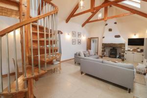 a living room with a staircase and a couch at Riverside Barn in Truro