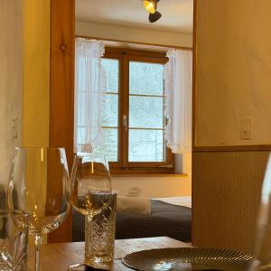 a table with two wine glasses and a window at Peacefull Mountains View in Kandersteg +25 photos