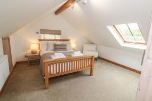 a bedroom with a bed and a bench in a attic at Riverside Barn in Truro