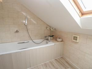 a bathroom with a bath tub in a attic at Riverside Barn in Truro +27 photos