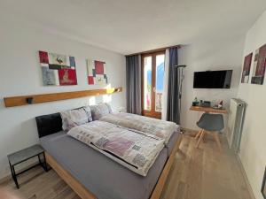 a bedroom with a bed and a television in it at Hotel Bellevue in Sierre
