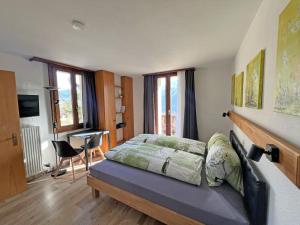 a bedroom with a bed and a desk in it at Hotel Bellevue in Sierre