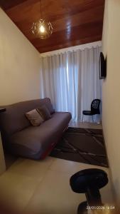 a living room with a couch and a window at Loftshorizontedesalvina in Búzios