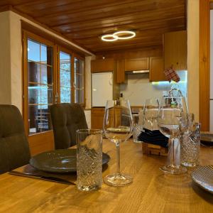a dining room table with wine glasses on it at Peacefull Mountains View in Kandersteg