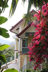 una casa con flores rosas a un lado. en Mayoyao View Inn en Banaue