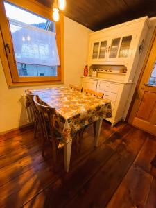 a kitchen with a table with chairs and a window at La casetta di Piera in Brusson