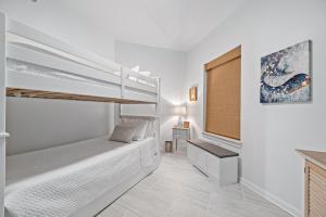 a white bedroom with a bunk bed and a window at Harbor Cove 404 in Orange Beach +60 photos