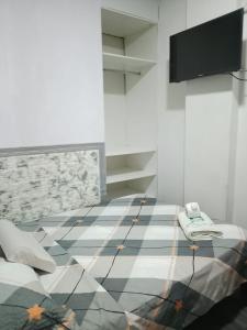 a room with a tiled floor and a flat screen tv at Hotel Ruah in Tumbes