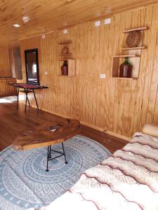 a room with a bed and a wooden wall at Cabaña monoambiente in Quellón +2 photos