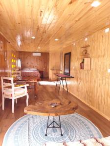 a wooden room with a bed and a table at Cabaña monoambiente in Quellón