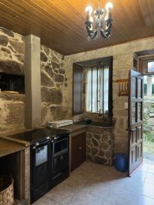 a kitchen with a stove and a sink and a chandelier at Casa Rural Melon in Melón