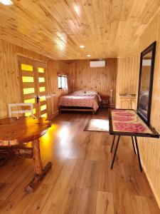 a bedroom with a bed and a table in a room at Cabaña monoambiente in Quellón