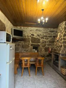 a kitchen with a wooden table and a refrigerator at Casa Rural Melon in Melón +19 photos