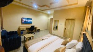 ein Hotelzimmer mit einem großen Bett und einem Schreibtisch in der Unterkunft Clear Gates Hotel in Ekete