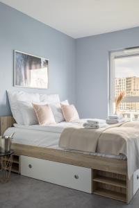 a white bedroom with a large bed with white pillows at Hygge Amber Aparts - 9th floor in Gdańsk Letnica +20 photos