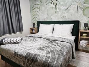 a bedroom with a large bed with a green headboard at Kuca za odmor PETAR u blizini Parka prirode PAPUK in Lisičine