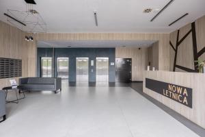 an empty lobby with a newza lending sign in a building at Hygge Amber Aparts - 9th floor in Gdańsk Letnica
