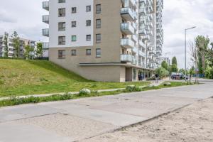 an empty street in front of a tall building at Hygge Amber Aparts - 9th floor in Gdańsk Letnica