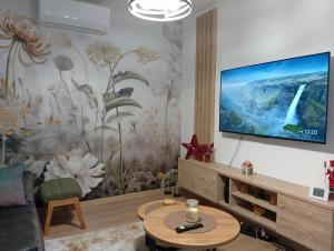 a living room with a flat screen tv on a wall at Kuca za odmor PETAR u blizini Parka prirode PAPUK in Lisičine