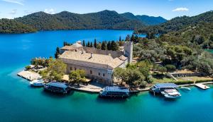an island in the middle of a lake with boats at Apartment Anka Polače in Polače