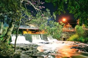 a waterfall in a park at night at Diony in Brotas