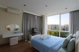 een slaapkamer met een blauw bed en een groot raam bij My Resort Huahin by MR.JAY in Hua Hin