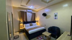 ein Hotelzimmer mit einem Bett und einem Stuhl in der Unterkunft Clear Gates Hotel in Ekete