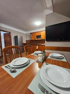 a dining room table with plates and utensils on it at Keller Apartman in Cserszegtomaj +2 photos