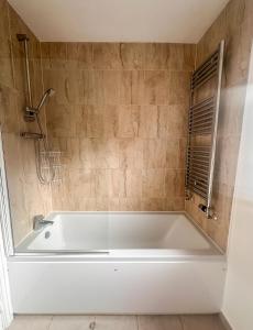 a white bath tub in a bathroom with a shower at Vyn's Holiday home - Sleeps 6 in Cardiff +19 photos