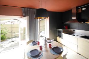 a kitchen with a wooden table with plates on it at Milk River - beach front, railway station, lake view in Varenna