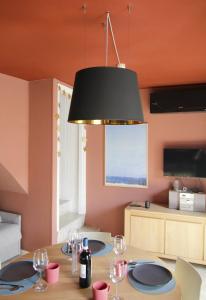 a dining room with a table with glasses and a lamp at Milk River - beach front, railway station, lake view in Varenna