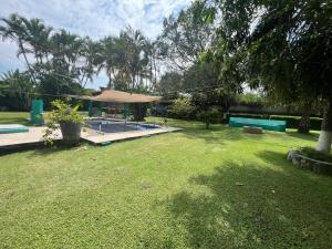 a large yard with a pool and a umbrella at Exclusive paradise surrounded by nature in Alpuyeca
