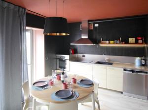 a kitchen with a wooden table with chairs and a dining room at Milk River - beach front, railway station, lake view in Varenna