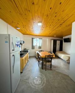 a kitchen and dining room with a table and a refrigerator at Lizkar Alojamientos in Esquel