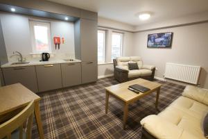 a living room with a couch and a table at Ayre Hotel & Ayre Apartments in Kirkwall