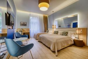 a bedroom with a bed and a desk and a chair at Salvator Boutique Hotel vegan-friendly in Prague