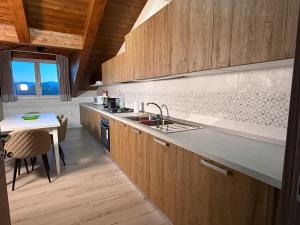 a kitchen with wooden cabinets and a sink and a table at La Dimora Certosina in Padula