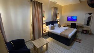 ein Hotelzimmer mit Bett und Fernseher in der Unterkunft Clear Gates Hotel in Ekete
