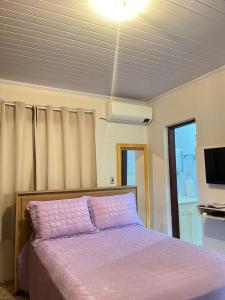 a bedroom with a bed with a purple blanket at Raízes do Cerrado in Cavalcante +4 photos